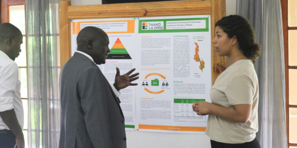 a CHE researcher discussing her work with a senior Ugandan policy-maker at the Malawi workshop 2019